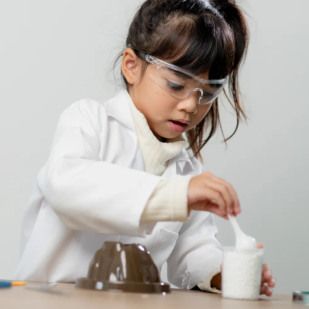 A young child using a spoon during a science experiment at Bright Beginnings Academy daycare
