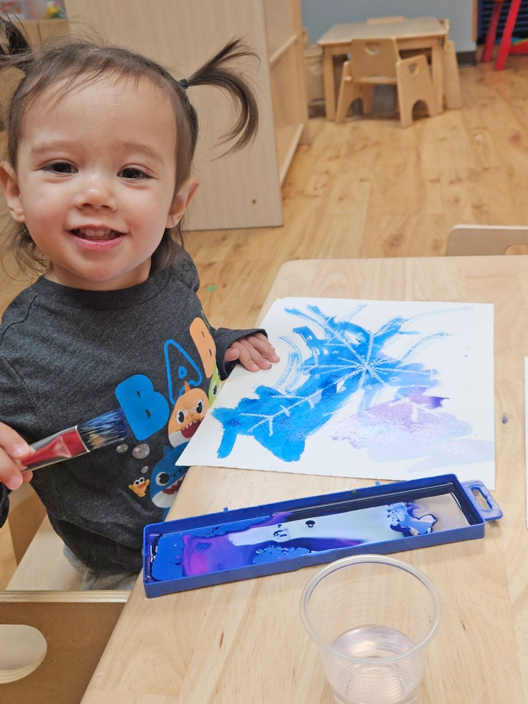 Child coloring with blue crayon at a Bright Beginnings Academy daycare.
