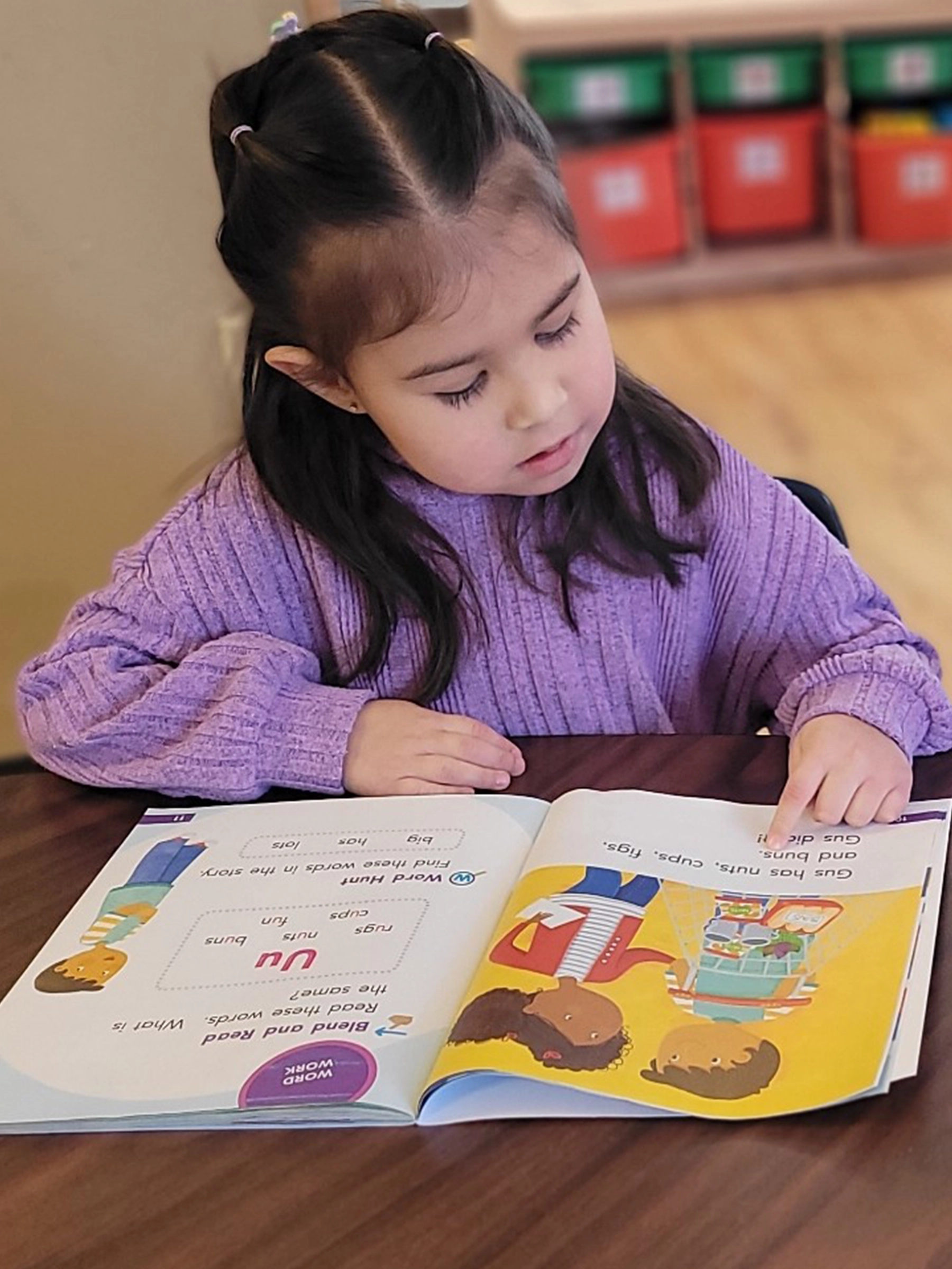 A child in purple reading a book at Bright Beginnings Academy daycare.
