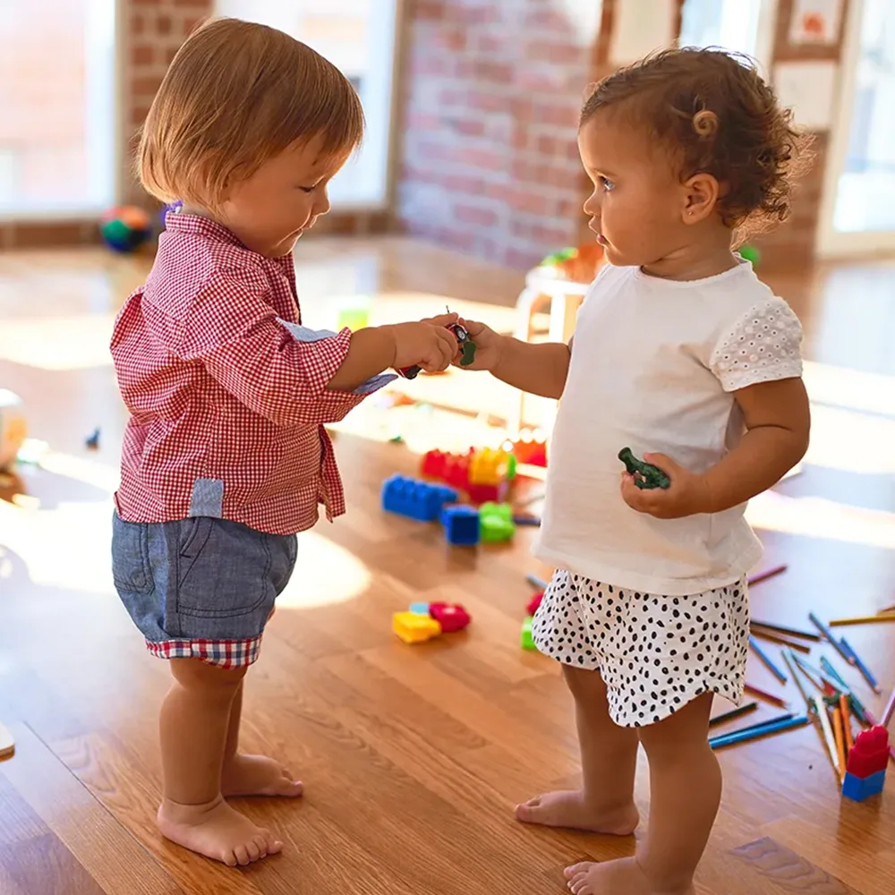 Two toddlers sharing toys at a Bright Beginnings Academy daycare