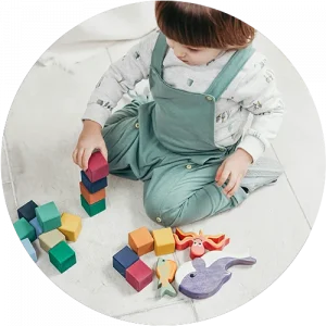 A child playing with blocks on the floor at a Bright Beginnings Academy daycare